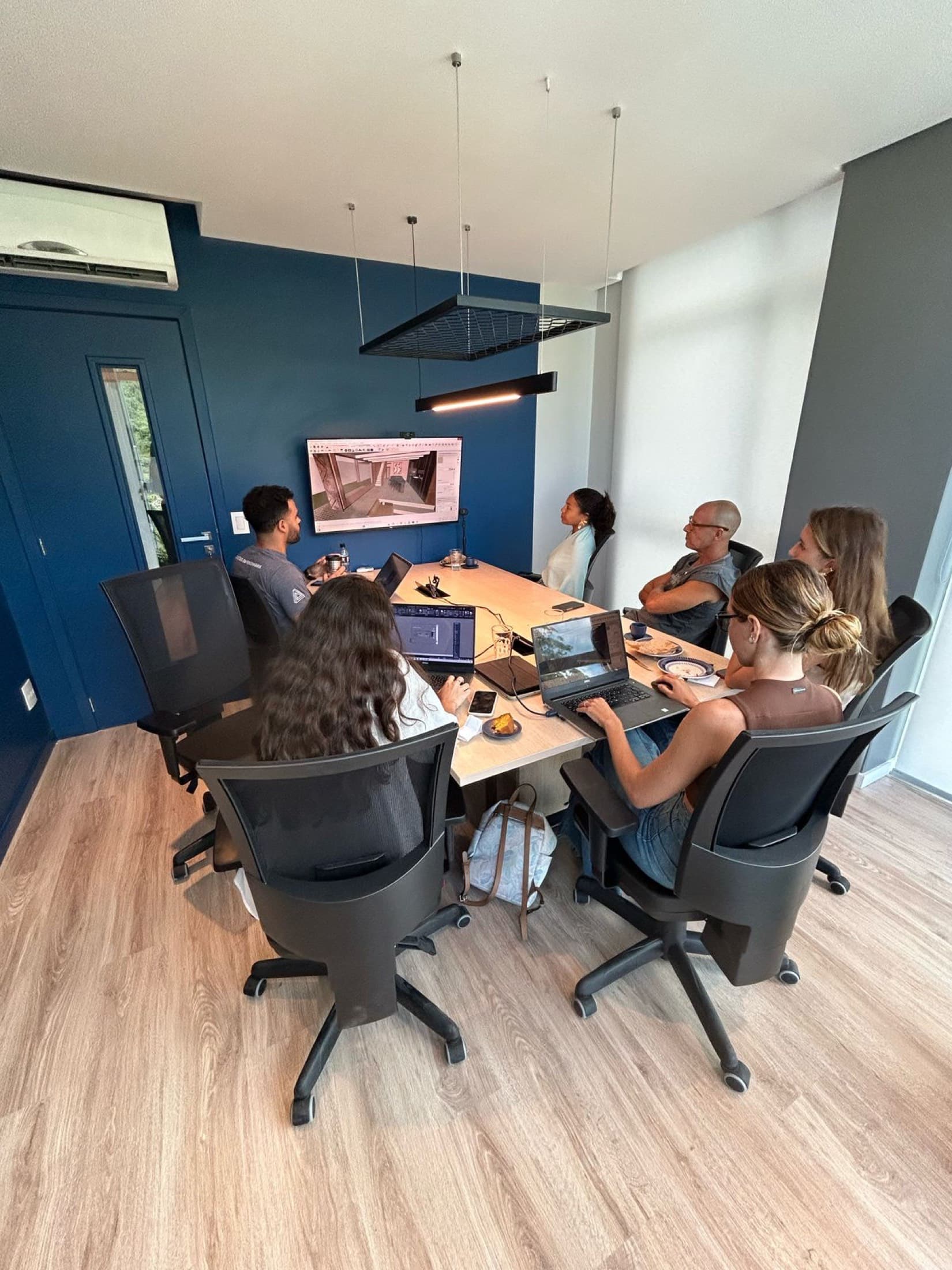 Reunião de equipe no escritório da Pronto!, revisando o projeto em tela